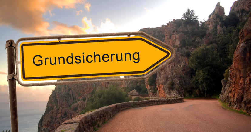 Straßenschild mit Aufschrift "Grundsicherung"